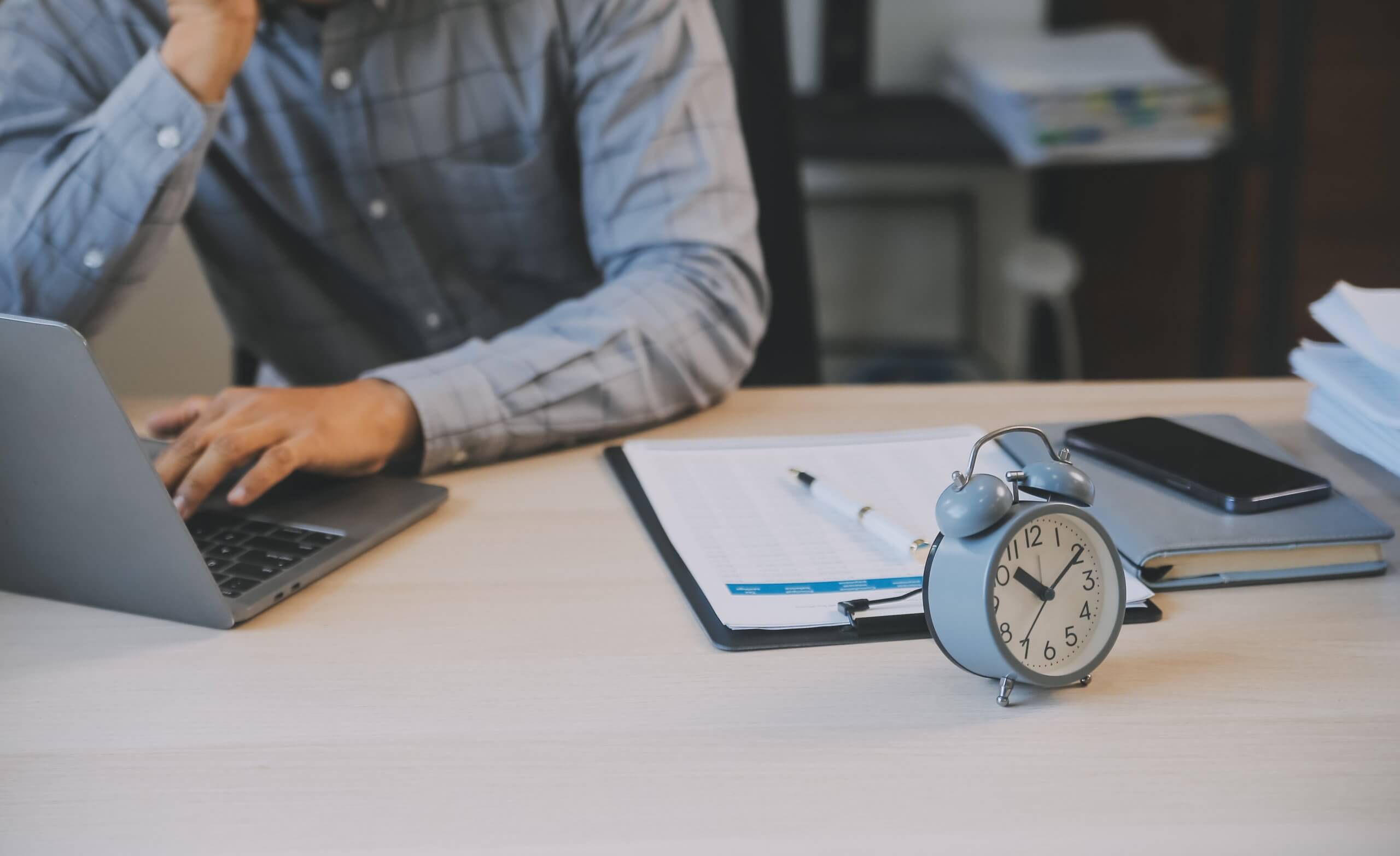 Person planning work rhythm with notebook and timer for focused breaks